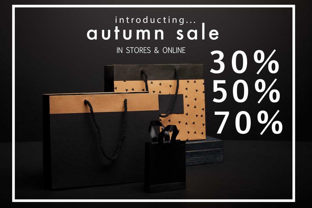 vista de cerca de las bolsas de compras dispuestas sobre fondo negro con la venta de otoño con 30, 50, 70 por ciento de descuento
 - Foto, Imagen