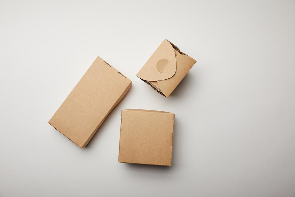 bovenaanzicht van noodle box en kartonnen dozen op witte ondergrond - Foto, afbeelding