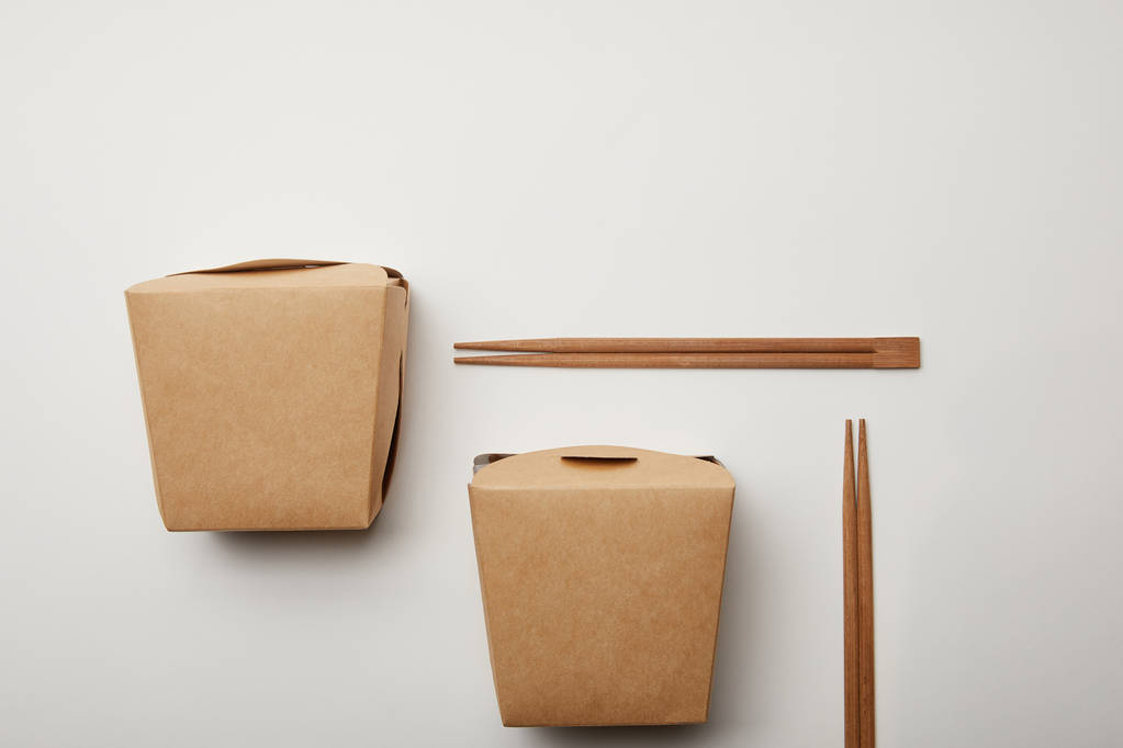 düz lay görücü usulü wok kutuları ve chopsticks beyaz yüzey, minimalist kavramı ile  - Fotoğraf, Görsel