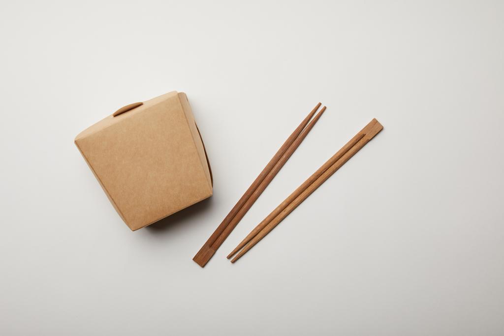 top view of arranged chopsticks and noodle box on white surface, minimalistic concept  - Photo, Image