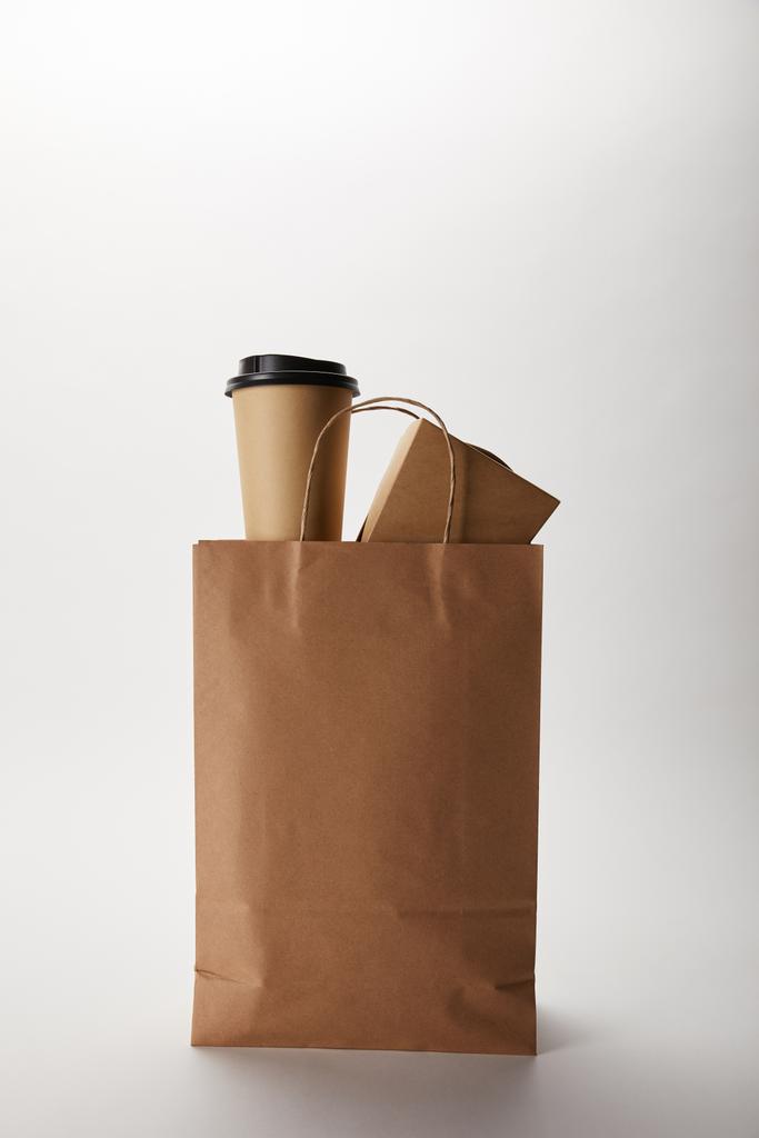 vue rapprochée du sac en papier de livraison de nourriture avec tasse à café jetable et wok box sur blanc
 - Photo, image