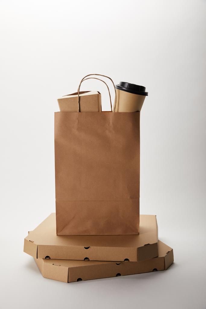 pizzadozen en voedsel levering papieren zak met wegwerp koffie cup en wok vak op wit - Foto, afbeelding