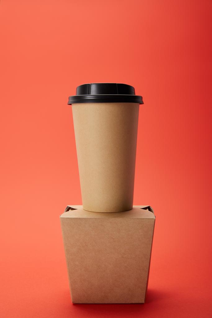 vue rapprochée de tasse à café jetable et boîte à nouilles sur rouge, concept minimaliste
  - Photo, image