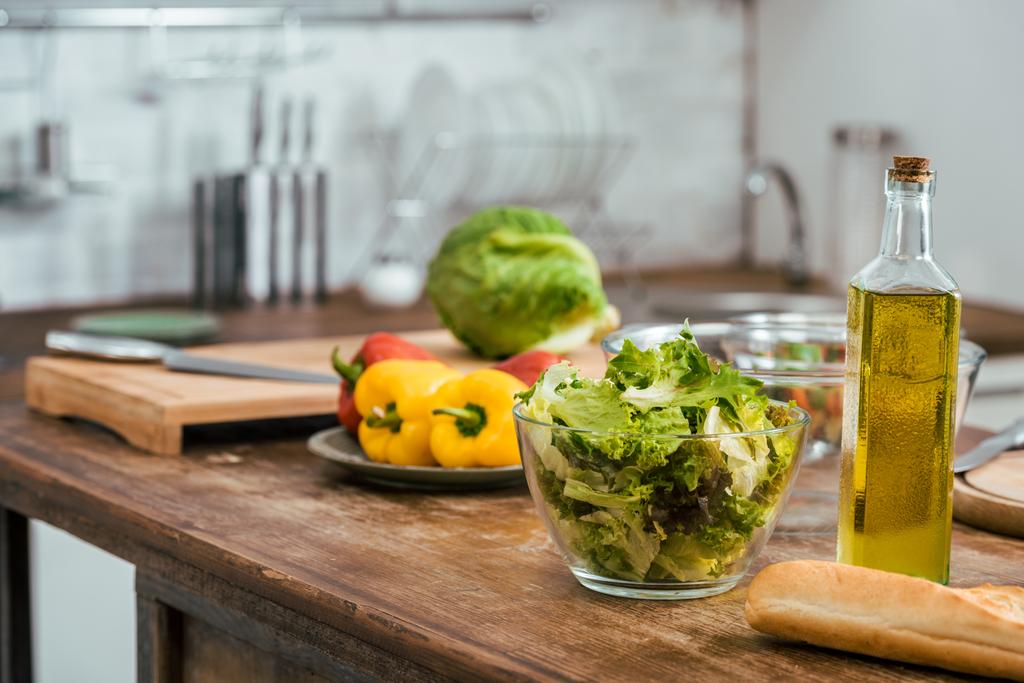 vegetables for salad and bottle of olive oil on tabletop in kitchen - Photo, Image