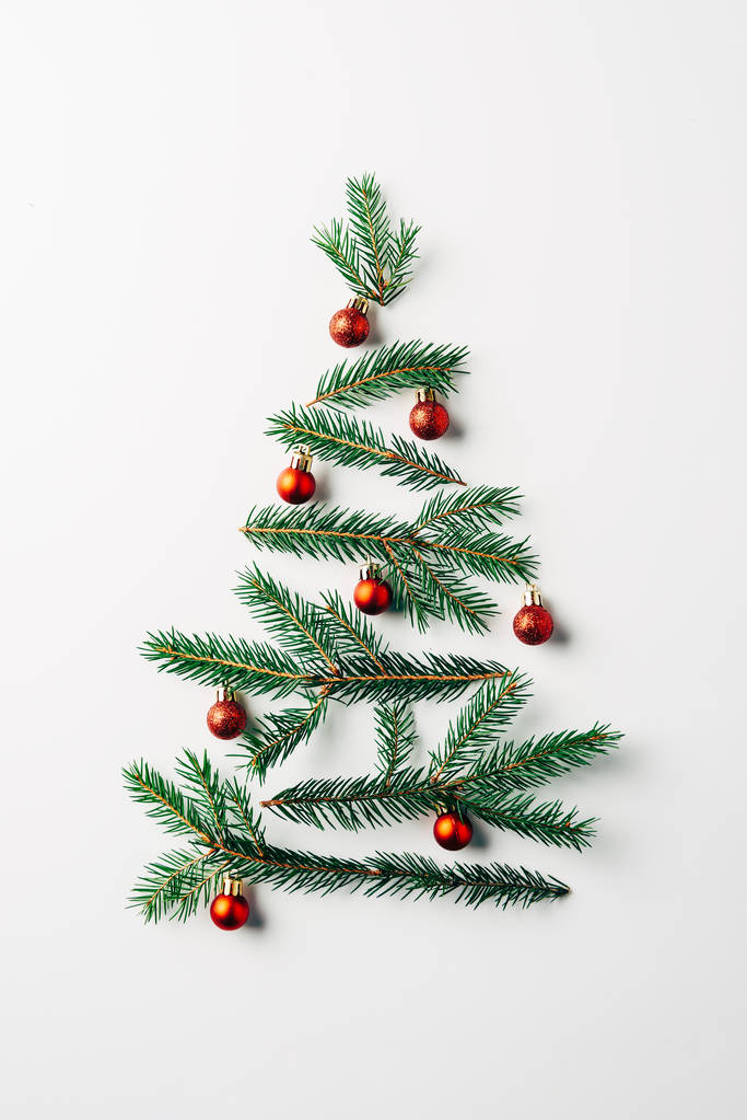 top view of pine branches arranged in christmas tree with toys on white background - Photo, Image