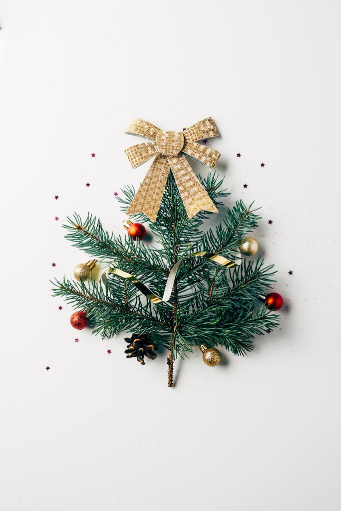 vista dall'alto del ramo di pino verde decorato come albero di Natale festivo con fiocco su sfondo bianco
 - Foto, immagini