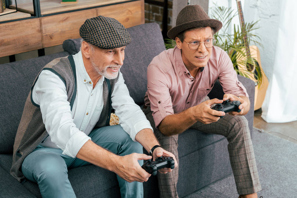 high angle view of handsome mature men playing with gamepads at home - Photo, Image