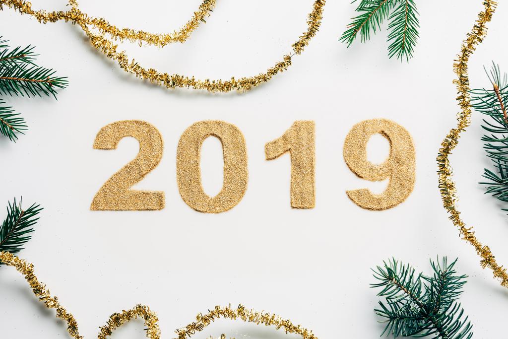 felülnézet 2019 év jel készült arany csillog, koszorúkat és a fenyő ágak a fehér hátteret - Fotó, kép