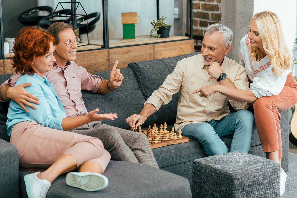 щасливі зрілі друзі збираються разом і грають в шахи вдома
 - Фото, зображення