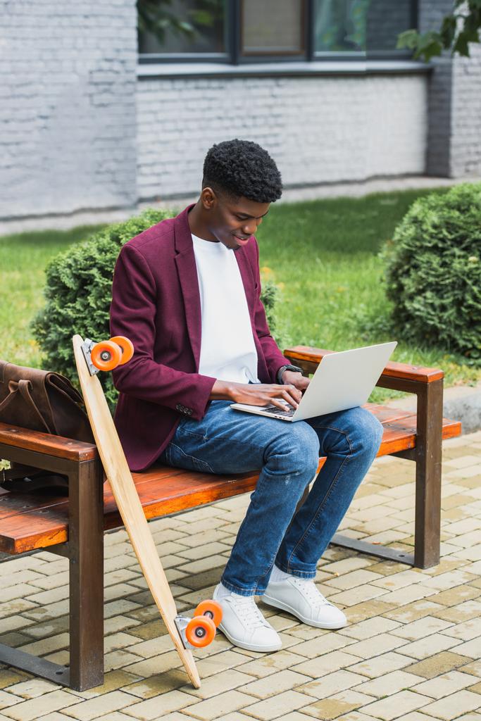 boldog afro-amerikai szabadúszó használ laptop utcában - Fotó, kép