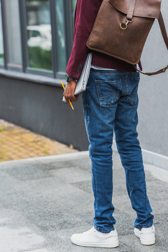 oříznuté shot studenta s notebooky a batoh stojící na ulici - Fotografie, Obrázek