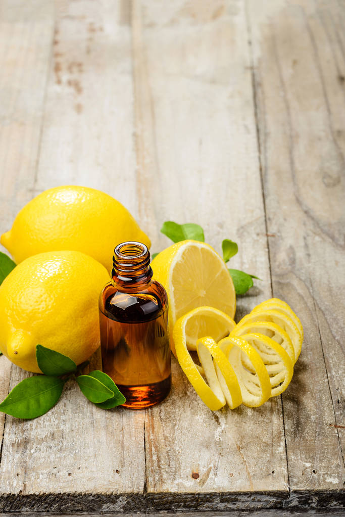 limon esans ve taze limon kabuğu ahşap tahta üzerinde - Fotoğraf, Görsel