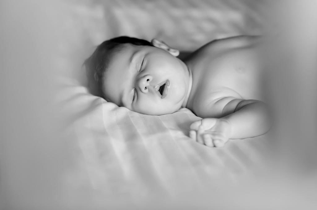 自宅のベッドで眠っているかわいい赤ちゃん男の子の黒と白の写真 ロイヤリティフリー写真 画像素材