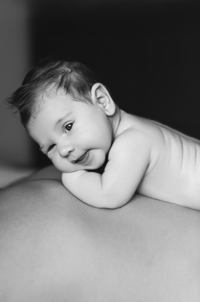 zwart-wit portret van baby jongetje opleggen van vader terug  - Foto, afbeelding
