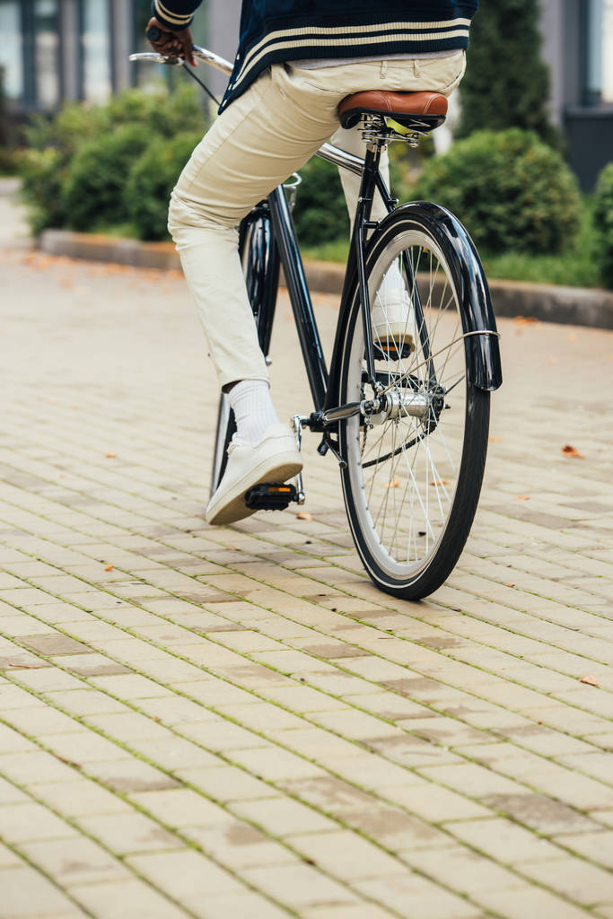 низький вид на стильний чоловік їде на велосипеді в місті
  - Фото, зображення