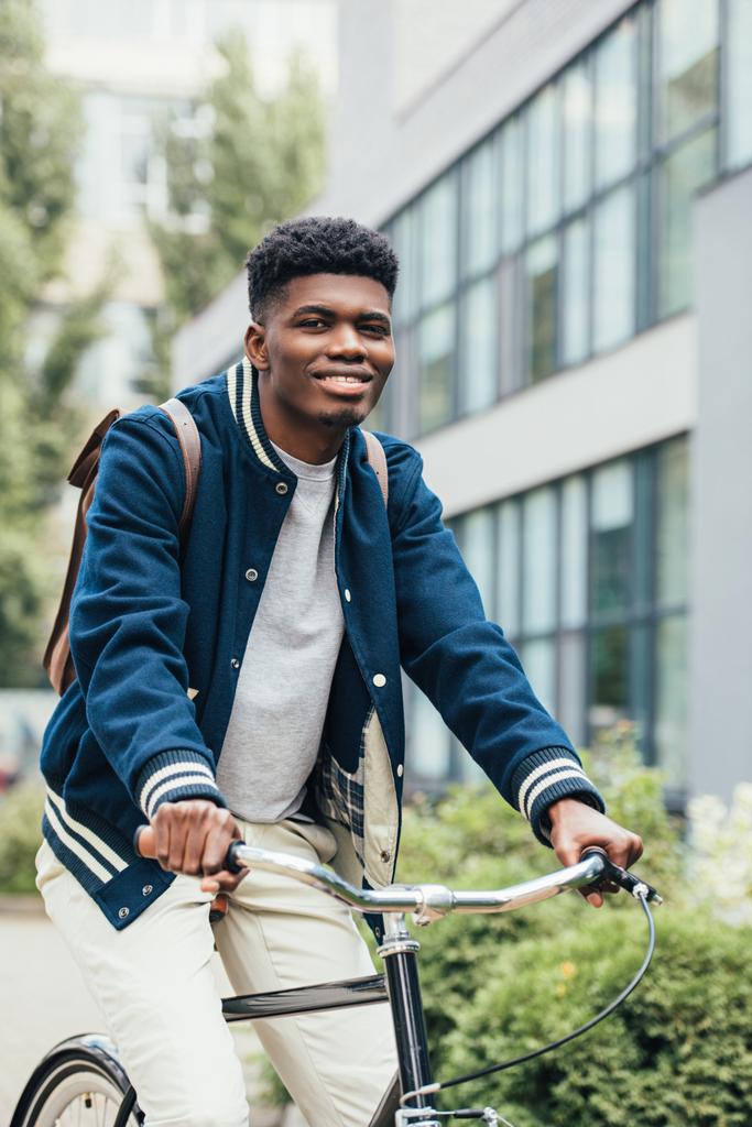 市でハンサムな陽気なアフリカ系アメリカ人乗り自転車 - 写真・画像