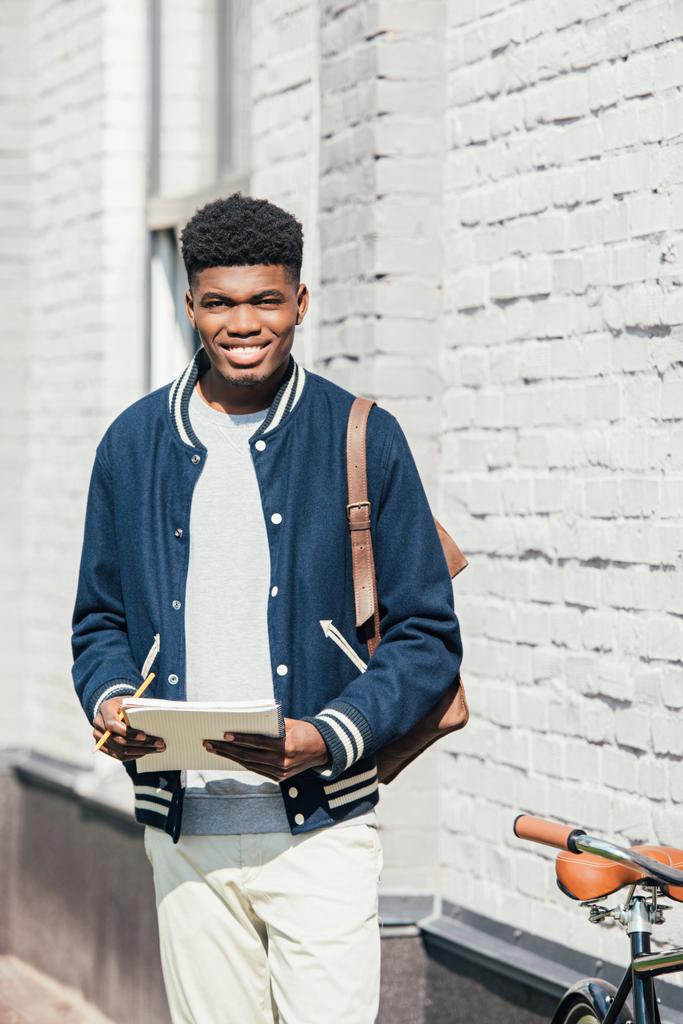 knappe stijlvolle Afrikaanse Amerikaanse student holding leerboek  - Foto, afbeelding