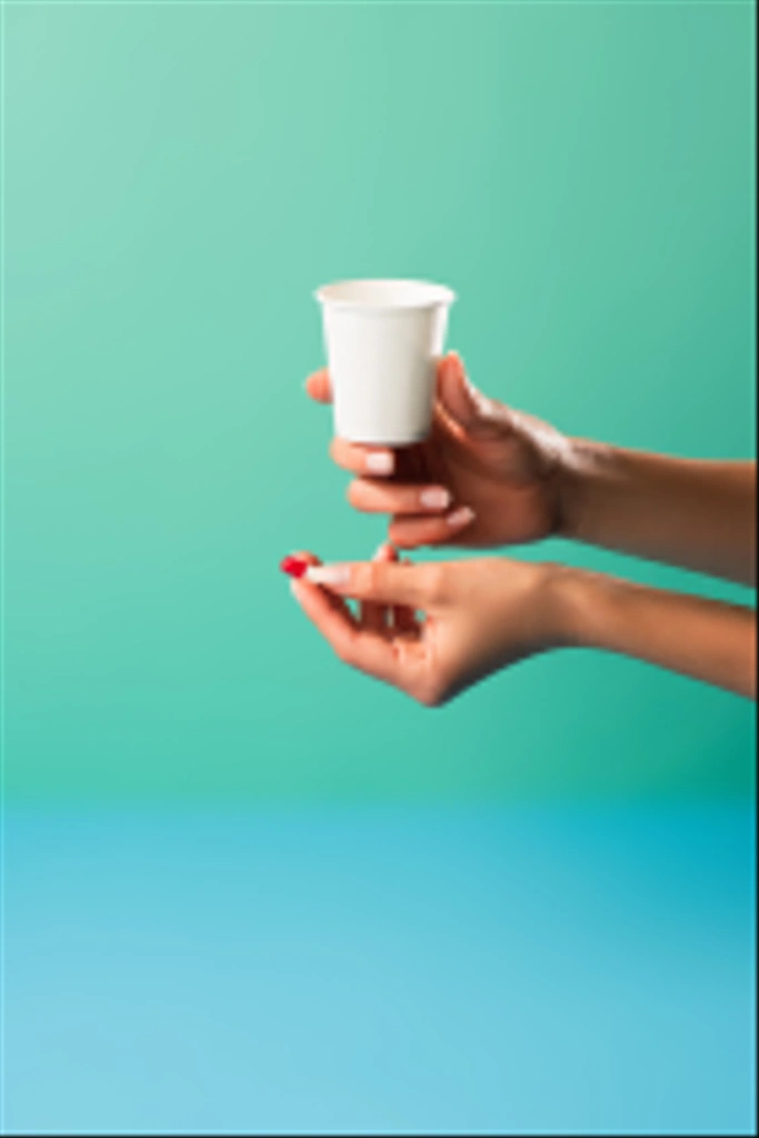 cropped shot of person holding small cup and medical capsule isolated on green - Photo, Image