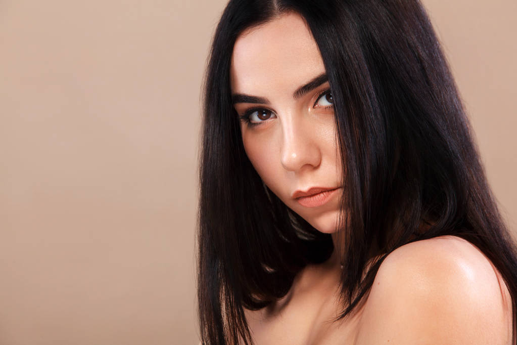 Closeup portrait of a beautiful woman. Pretty face of the young adult girl. Fashion model posing at studio. Cosmetology and spa concept. - Photo, Image