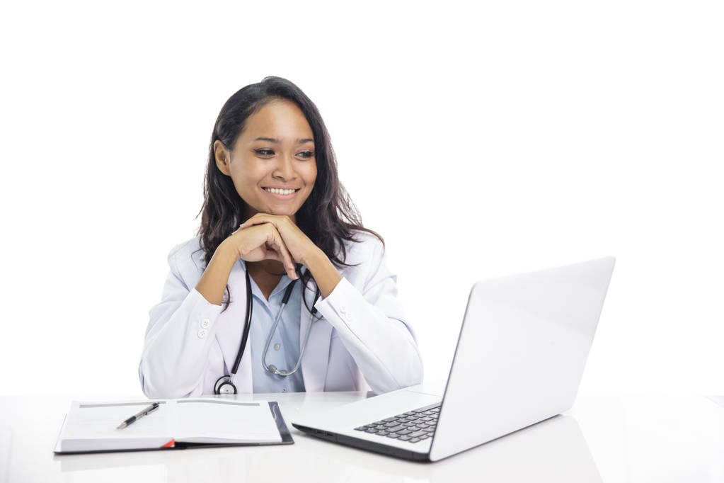 asiatische junge Arzt lächelnd während sitzen auf ihrem Arbeitsplatz und l - Foto, Bild