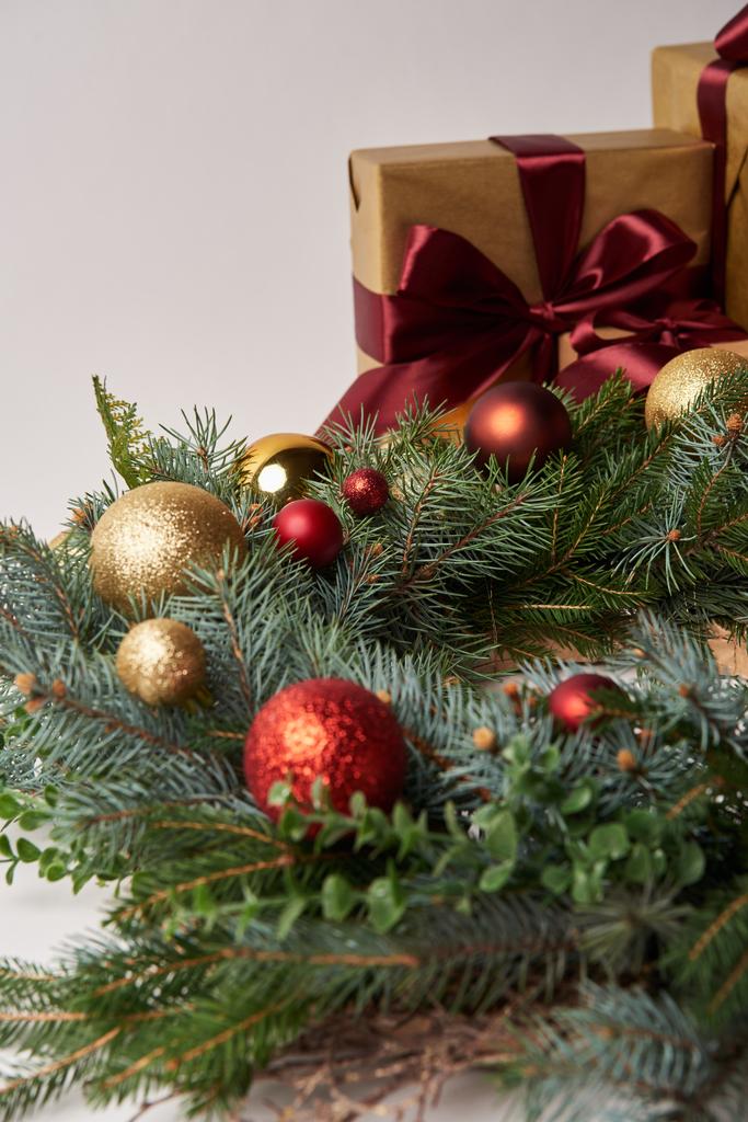 ghirlanda di abete natalizio con bagattelle rosse e dorate, scatole regalo isolate su bianco
 - Foto, immagini