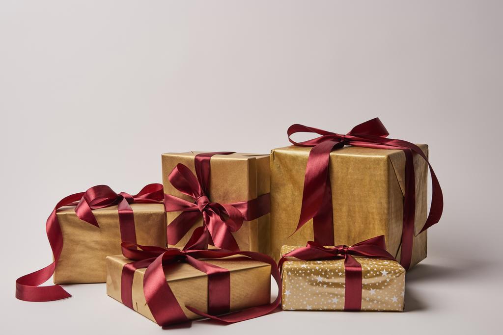 Різдвяні подарунки з бордовими стрічками ізольовані на білому
 - Фото, зображення