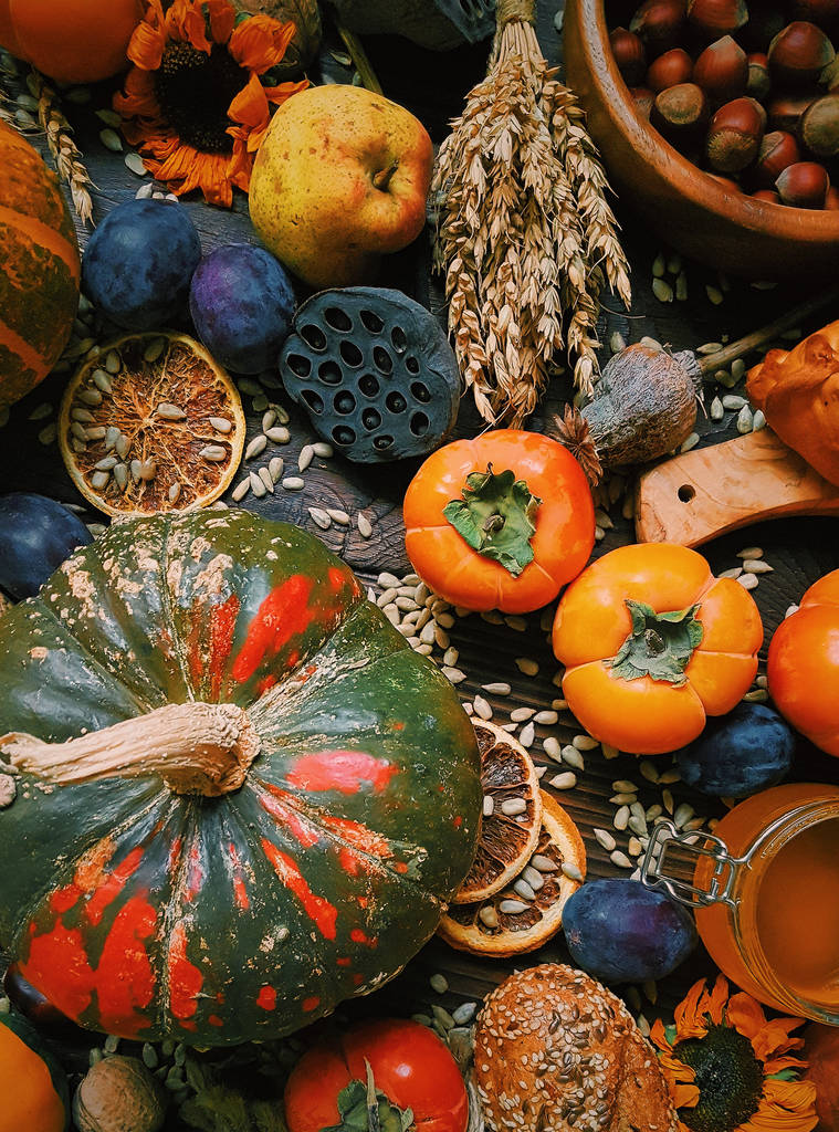 Podzimní zátiší, sklizeň, dýně, tomel, švestky, pšenice, domácí chléb na tmavém pozadí dřevěná, venkovský život - Fotografie, Obrázek