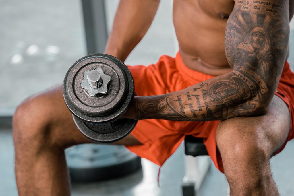 imagem recortada do atleta americano africano tatuado exercitando-se com halteres no ginásio
 - Foto, Imagem