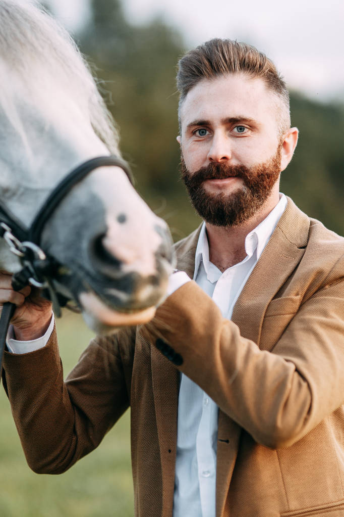 馬と牧場のアメリカン スタイルの結婚式。友人とは馬に乗って、夕暮れ時のカップルのフィールドで歩いてください。モダンなカップルは、式のためのアイデア. - 写真・画像