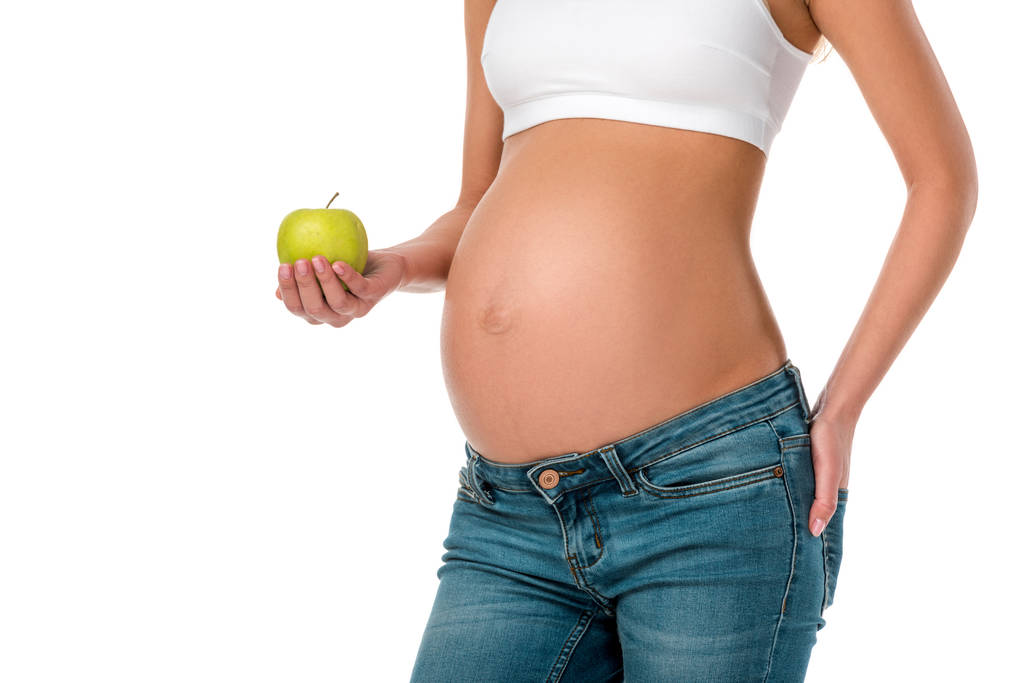 vue recadrée de la femme enceinte tenant pomme verte fraîche isolée sur blanc
 - Photo, image