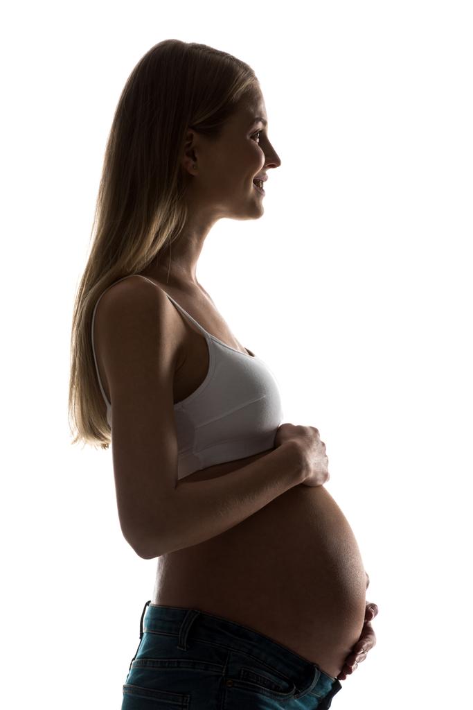 silueta šťastné těhotné ženy dotýká její břicho izolované na bílém - Fotografie, Obrázek