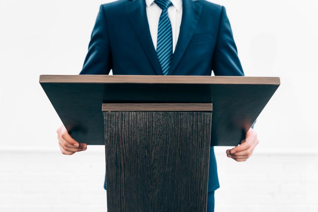 immagine ritagliata di docente in piedi sul tribuna del podio durante il seminario nella sala conferenze
 - Foto, immagini