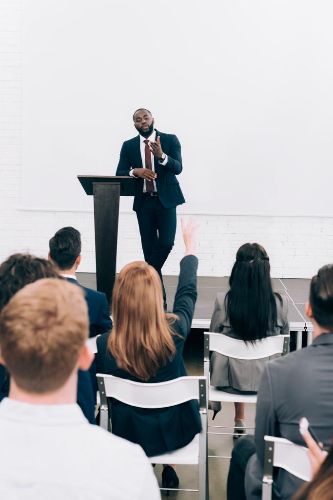 Afrikanisch-amerikanischer Dozent spricht mit Publikum und gestikuliert während des Seminars im Konferenzsaal - Foto, Bild