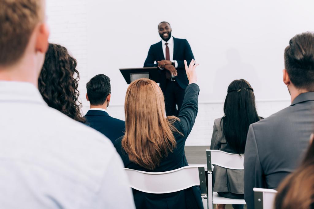 afro-americano palestrante conversando com o público durante seminário na sala de conferências, participante levantando a mão
 - Foto, Imagem
