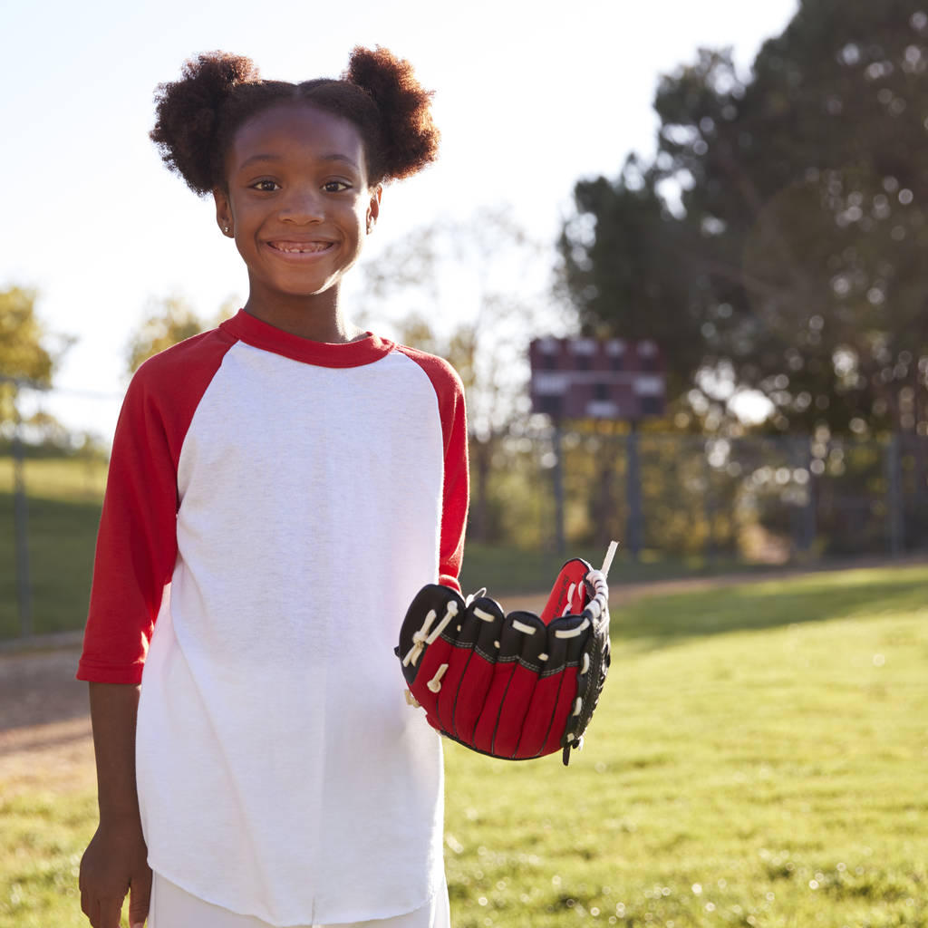 Молодая черная девушка с бейсбольной перчаткой улыбается
 - Фото, изображение