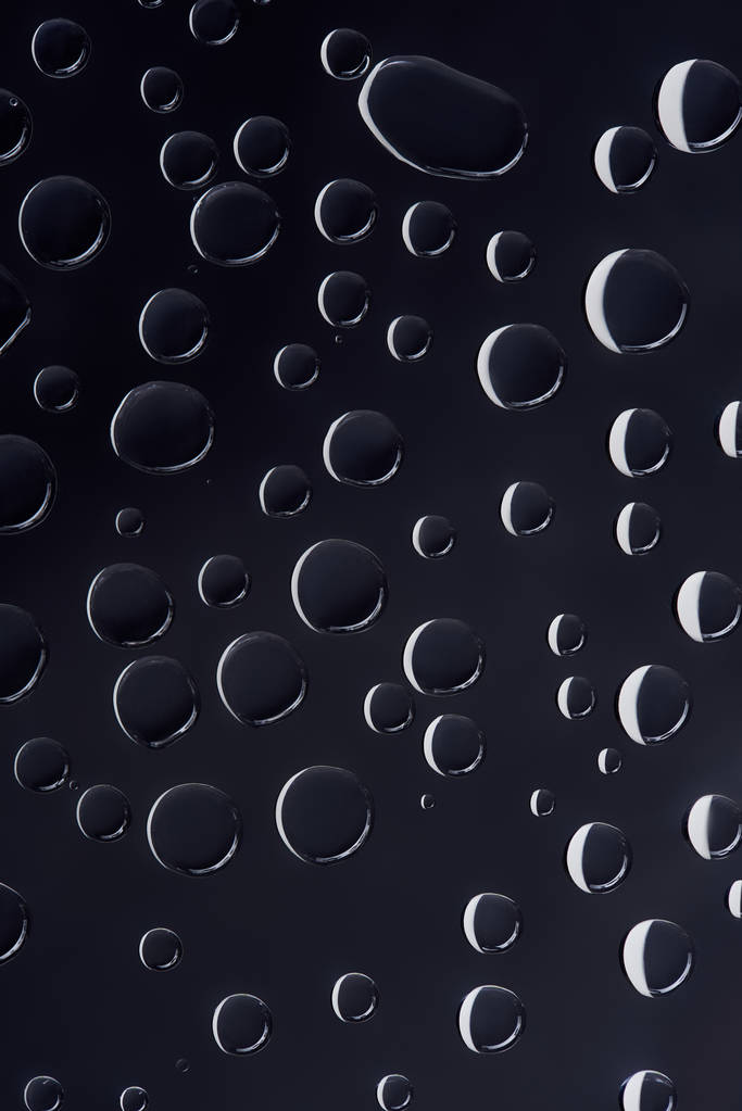 primo piano vista di gocce d'acqua trasparenti su sfondo astratto nero
 - Foto, immagini