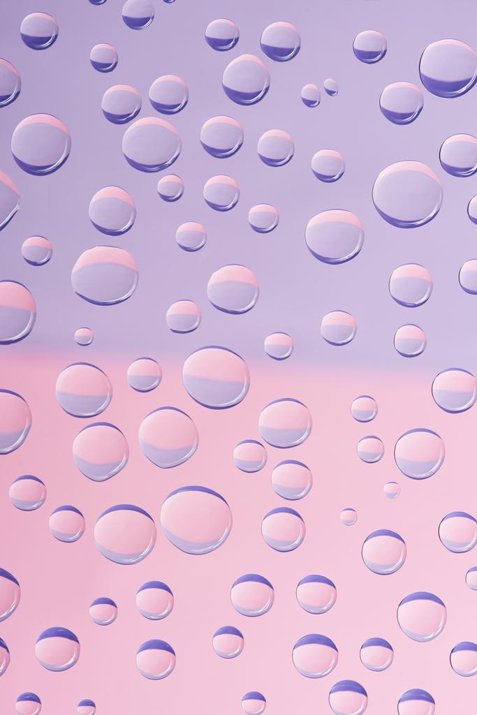 vue rapprochée de gouttes d'eau transparentes sur fond rose clair
 - Photo, image