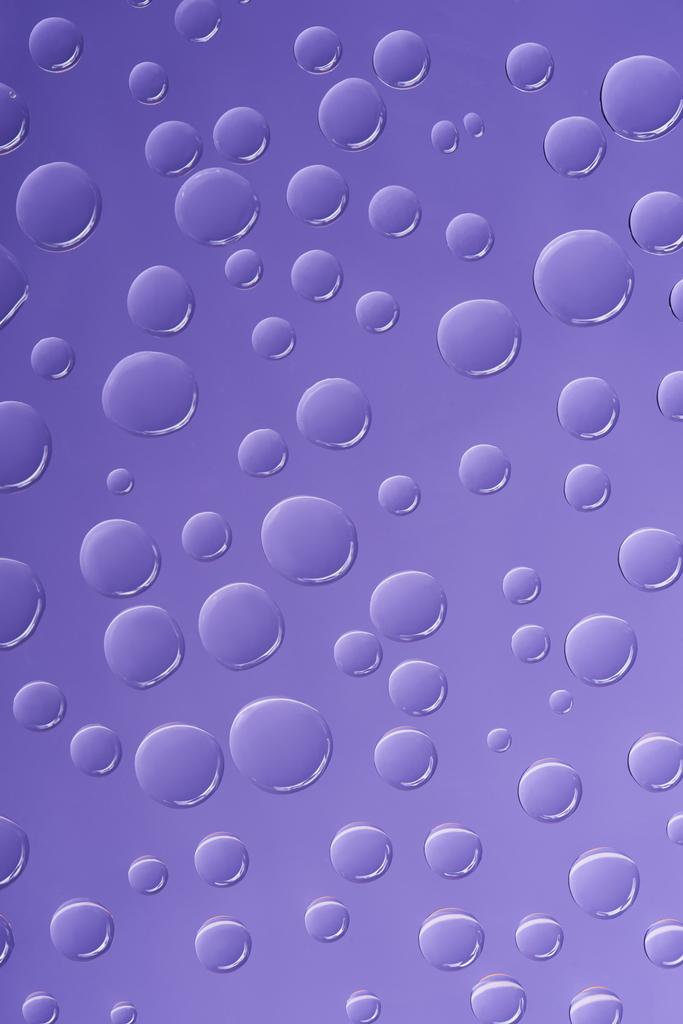 vista de cerca de gotas de agua transparentes sobre fondo púrpura
  - Foto, Imagen