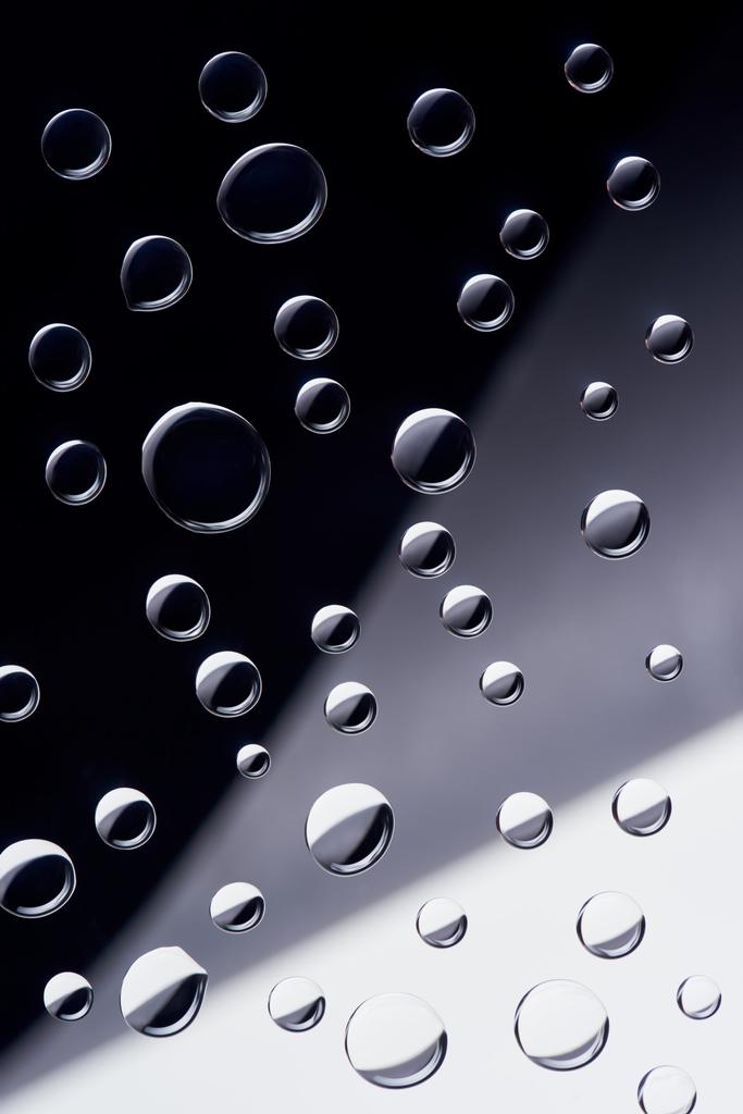close-up view of transparent water drops on black, grey and white background - Photo, Image