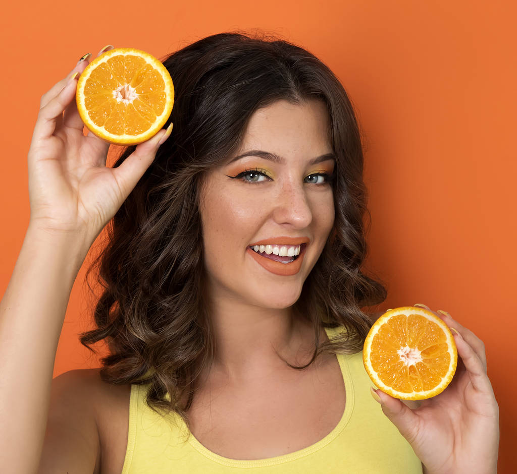 junge Frau posiert mit Orangenscheiben - Foto, Bild