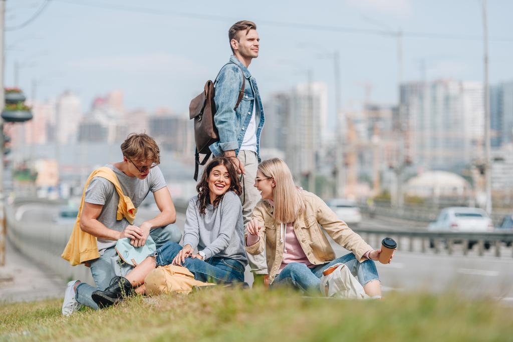 Gruppe junger lächelnder Reisender mit Rucksäcken in neuer Stadt - Foto, Bild