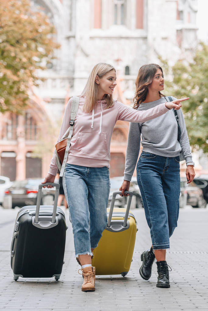 turistas do sexo feminino com mochilas e bagagem andando na rua da cidade
 - Foto, Imagem