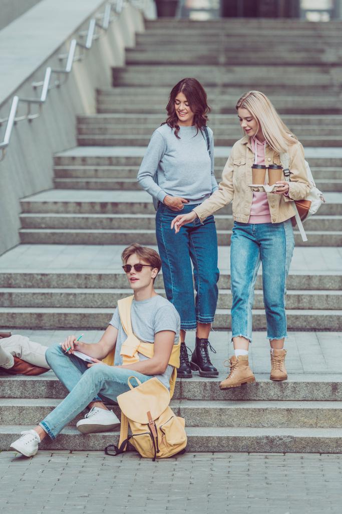 Frauen brachten Kaffee für Freundin auf der Stadttreppe in neue Stadt - Foto, Bild