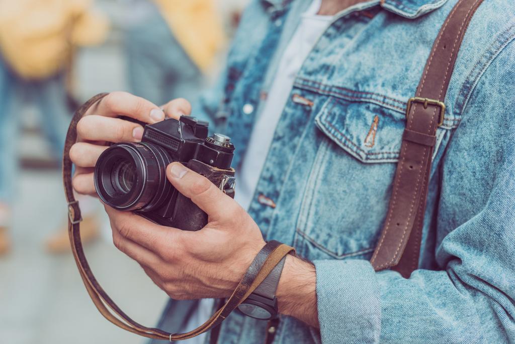 обрізаний знімок туриста з фотоапаратом в руках
 - Фото, зображення