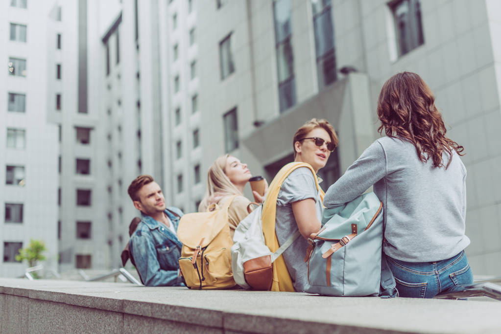 giovani coppie alla moda sui viaggiatori parlando e seduti in città urbana
  - Foto, immagini