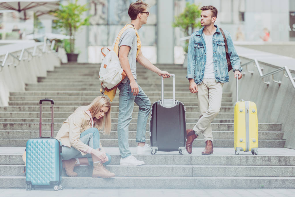 turistas jóvenes y elegantes con mochilas y bolsas de viaje en las escaleras de la ciudad
 - Foto, imagen