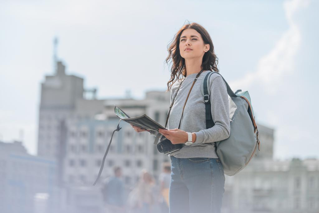 atractiva turista femenina con cámara fotográfica, mochila y mapa caminando en la ciudad
 - Foto, imagen