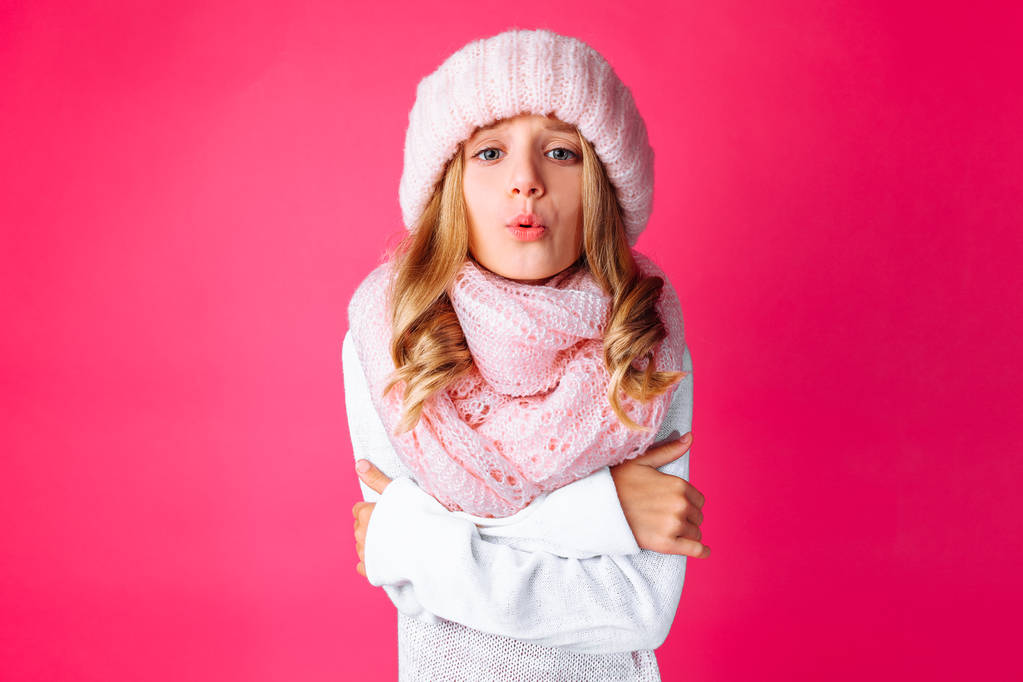 Kuva söpö teini tyttö valkoinen pusero seisoo eristetty vaaleanpunainen tausta kuvaa, että hän on kylmä, yllään lämmin vaaleanpunainen hattu ja lämmin huivi. Konsepti, talvi, kylmä
 - Valokuva, kuva