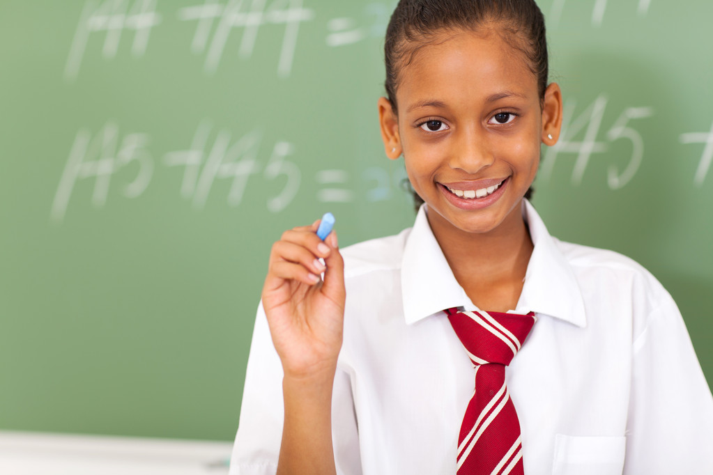 primární školačka drží křídy před tabuli - Fotografie, Obrázek