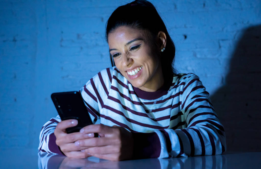Felice attraente giovane donna in chat su incontri applicazione a casa la sera con il telefono cellulare in incontri on-line, nuovo concetto di tecnologia in luce scura
. - Foto, immagini